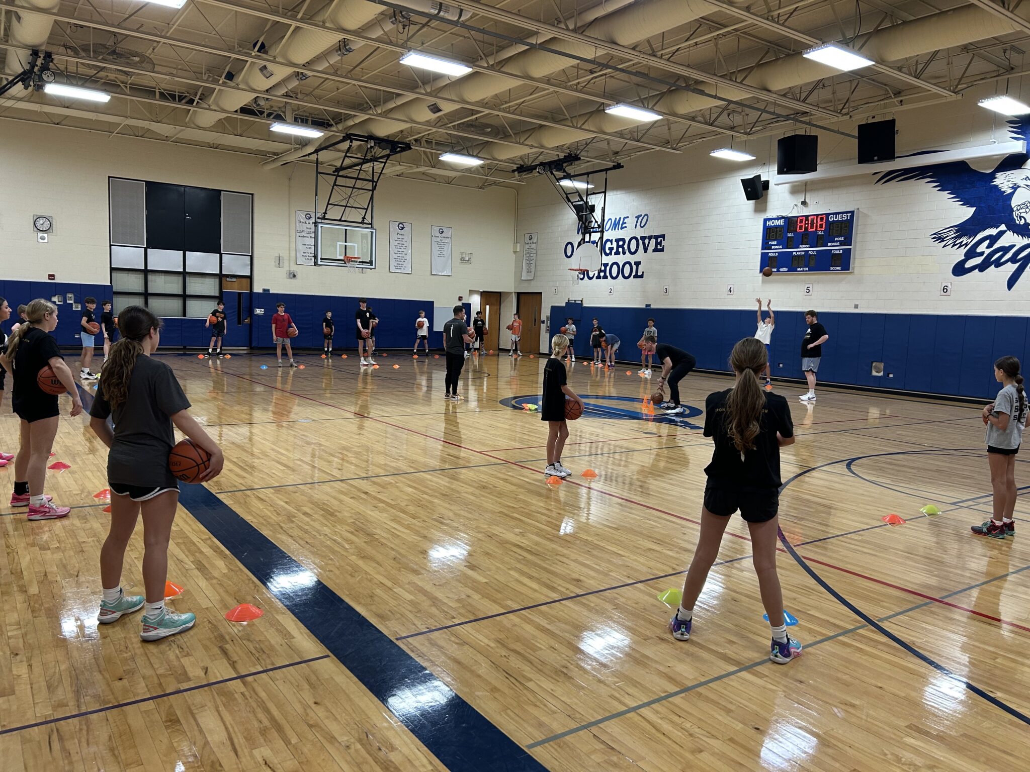 Students playing basketball in a school gymnasium.